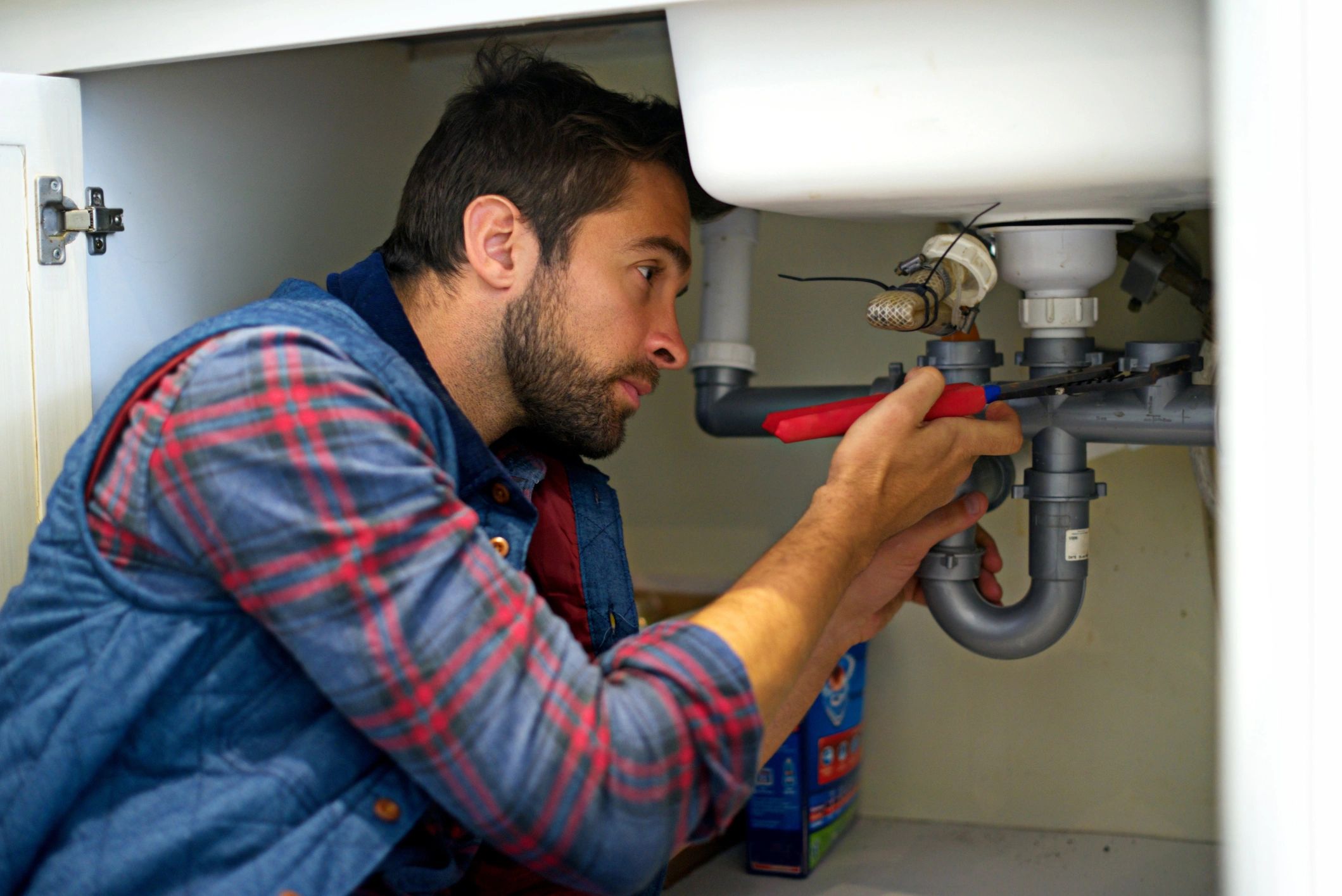 Plumber working under a sink